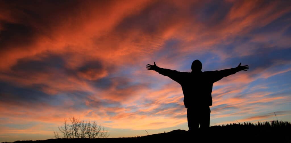 Unrecognizable Man With Arms Outstretched in Worship